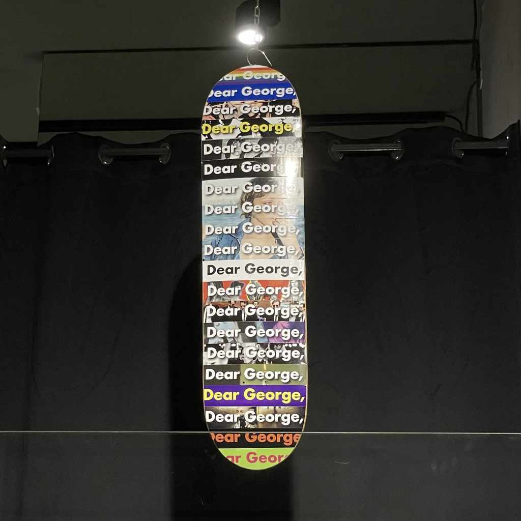 foto skateboard con tutti adesivi colorati con scritta Dear George,
